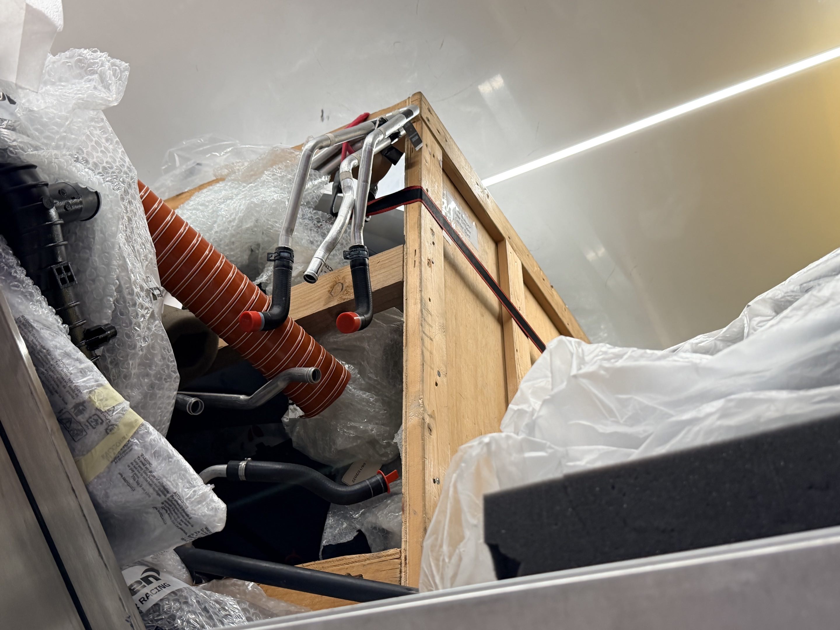 The upper level of a racing parts hauler stacked high with various race car parts